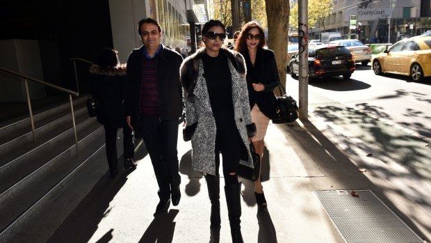 Pankaj Oswal (left) and his wife Radhika (right) and daughter Vasundhara leave court in Melbourne.