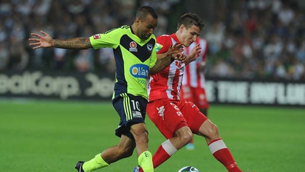 Victory two-step: Melbourne's Archie Thompson battles with Heart's Michael Marrone at AAMI Park. Victory won 2-1.