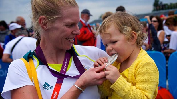 Sarah Tait shows her daughter Leila her silver medal after winning at Eton Dorney.
