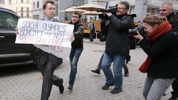 An unidentified man chases gay rights activist Nikolai Alexeyev (left, front), as he was protesting in September against a ban on staging a gay pride parade during the Sochi Games.