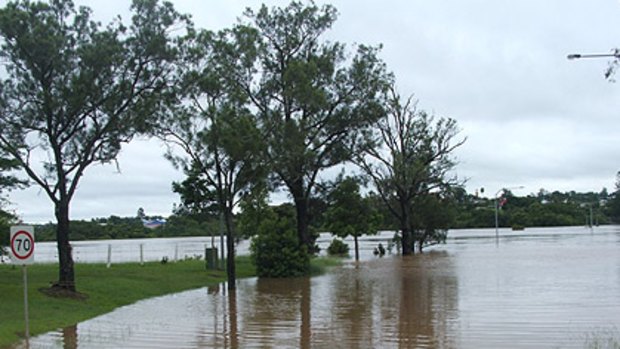 The flooded Mary River on Exhibition Road, Gympie, today, where two bridges have been submerged by water.
