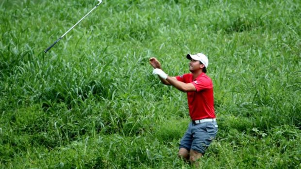 Going gets rough: Jason Day saved par at the second hole after wading through a creek and pitching out of heavy rough to within 10 feet of the flag.