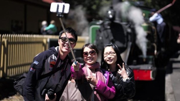 Tourists take a selfie in front of Puffing Billy at Lakeside station near Melbourne.