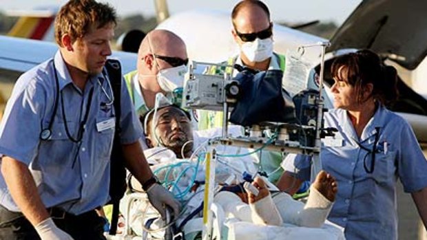 Rescue mission ... one of the passengers from the boat that exploded on Thursday is carried off a Royal Flying Doctor flight for treatment in Perth yesterday.