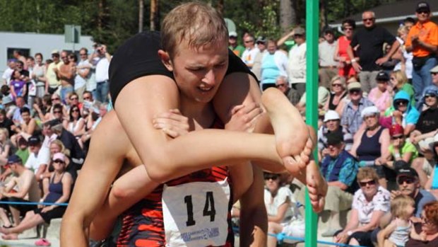 Alan Voogle and Kristi Viltroop of Estonia compete during the Wife-carrying World Championships in Sonkajärvi, central Finland. <i>Photo: STR/Lehtikuva /Joonas Hukkanen</i>