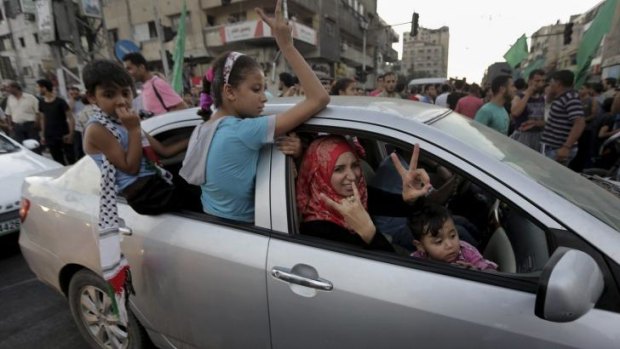 A Palestinian family flashes victory signs in the northern Gaza Strip.