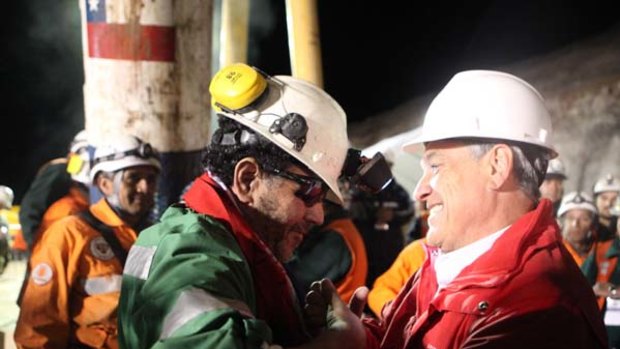 Chilean President Sebastian Pinera speaks to the last miner to be rescued, Luis Urzua.