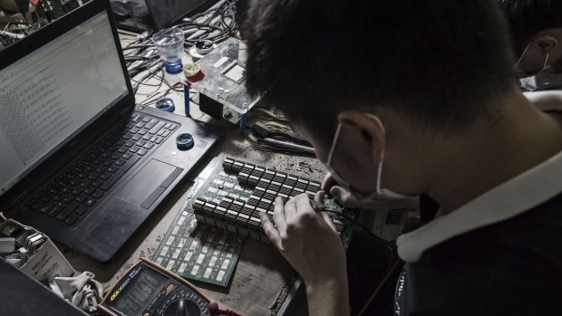 A technician makes repairs to bitcoin mining machines at a mining facility operated by Bitmain Technologies in Ordos, Inner Mongolia, China.