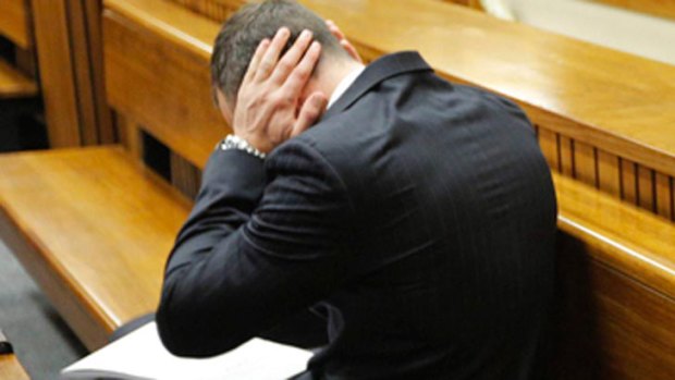 Too much: Oscar Pistorius covers his ears as graphic details of his girlfriend's death are read out in court.