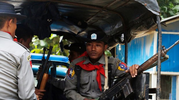 Myanmar police officers sit in a truck as they provide security in Maungdaw, Rakhine State, Myanmar.