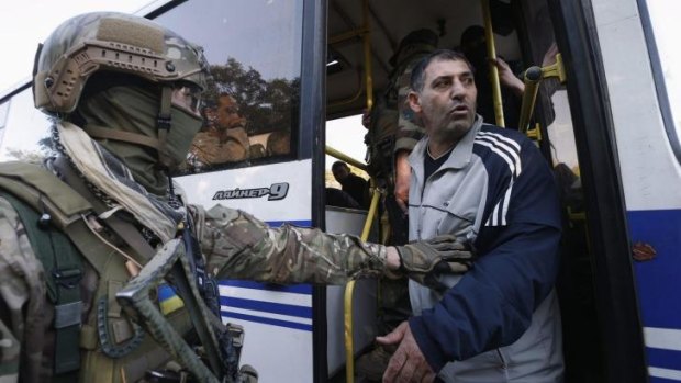 Under guard: A pro-Russian prisoner-of-war gets off a bus in Donetsk, eastern Ukraine.