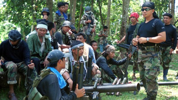 Abu Sayyaf spokesman Abu Sabaya, right foreground, with militants in Basilan, the Philippines. 