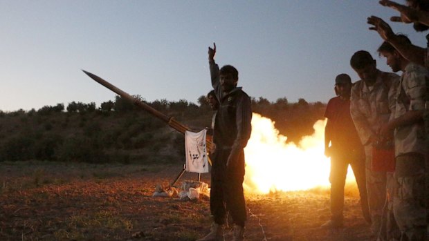 Tajammu Al-Ezza brigade fighters fire a shell towards the forces of Syria's President Bashar al-Assad stationed at Salhab village, in the Hama countryside on Friday. 