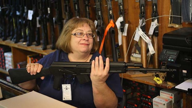 Buyer rush ... Cindy Sparr packs a rifle for a customer in Tinley Park, Illinois. The National Rifle Association has said it will offer ''meaningful contributions'' to the gun debate.