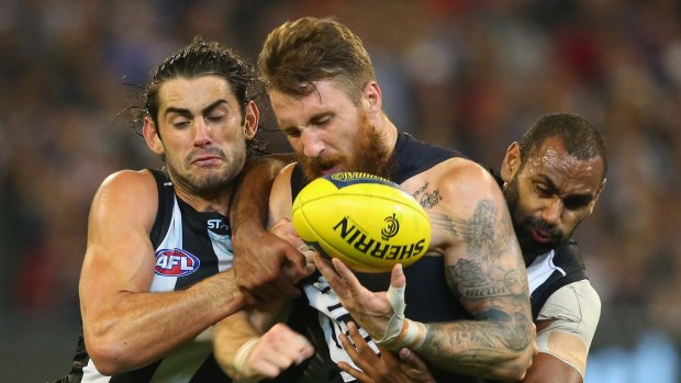 Collingwood's Brodie Grundy lays a tackle on Zach Tuohy of the Blues.