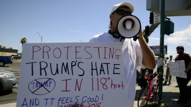 An anti-Trump protester chants at an intersection a block away from a Trump rally in Arizona on Saturday.  