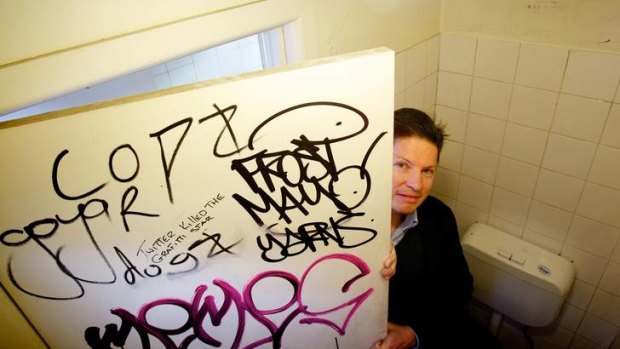 Professor Nick Haslam with graffiti in the toilets at the University of Melbourne.