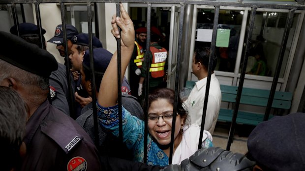 A woman weeps for her injured relatives as she tries to speak to security at a hospital in Lahore on Sunday. 