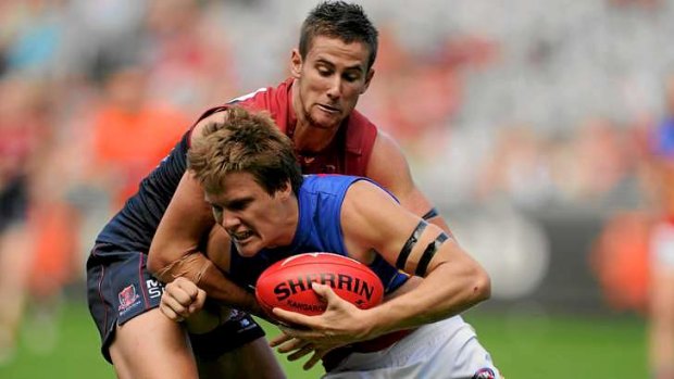 Melbourne's Jeremy Howe tackles Brisbane's Jared Polec.