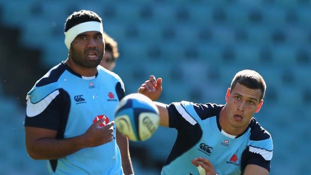 Boys in blue &#8230; Grayson Hart passes the ball as No.8 Wycliff Palu looks on at the Waratahs' training session yesterday.
