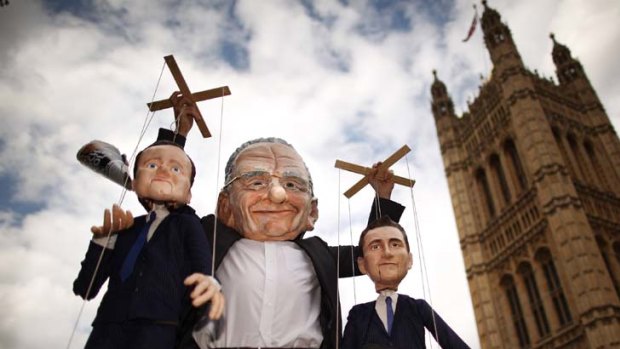 Puppets representing British Prime Minister David Cameron, left, and Culture Secretary Jeremy Hunt are held aloft by "Rupert Murdoch" at the launch of the campaign group Hacked Off in London.