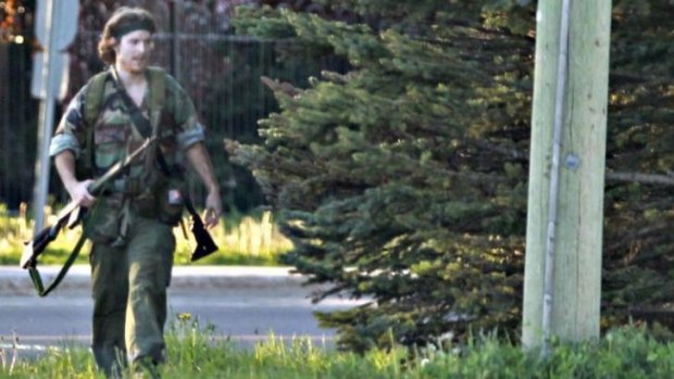 A heavily armed man that police have identified as Justin Bourque walks on Hildegard Drive in Moncton, New Brunswick, after several shots were fired in the area.