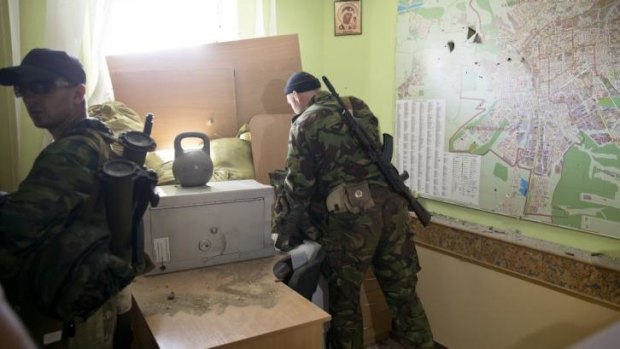 Pro-Russian rebels inspect the offices of an Ukrainian border troops military unit in Luhansk, eastern Ukraine, after taking it from government forces.