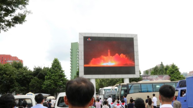 People watch a news broadcast on a missile launch in Pyongyang.