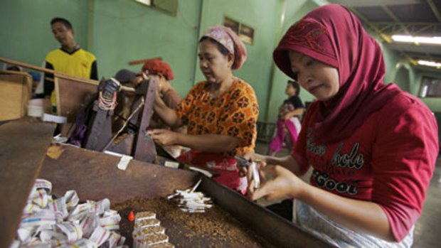 Hand made ... women work in pairs, rolling and cutting kretek cigarettes at a factory in Kudus. Each pair typically makes more than 5000 cigarettes each day.