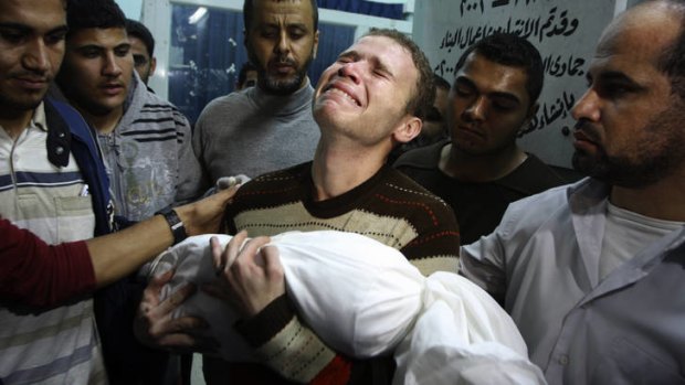 Grief ... the BBC journalist Jihad Misharawi weeps while he holds the body of his 11-month old son Ahmad.