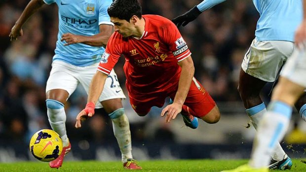 Falling fortunes: Liverpool striker Luis Suarez is tackled during the team's loss to Manchester City at Etihad Stadium.