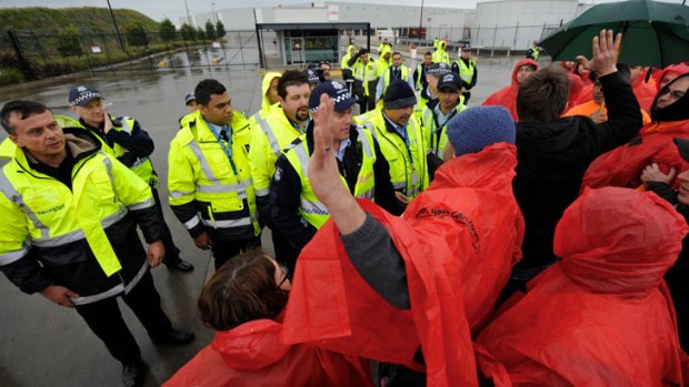 Security guards, police and workers face off.