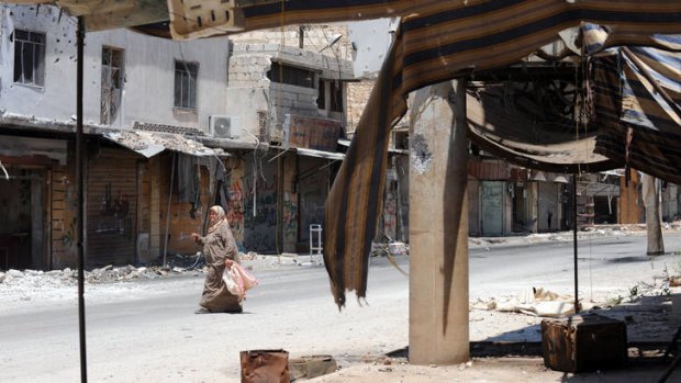 A woman crosses a street in the town of Atareb after clashes between Syrian soldiers and the Free Syrian Army.