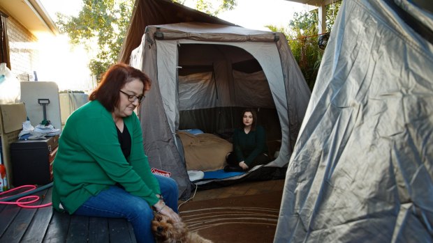 Tanya Martin and her family have been forced to live in tents in their backyard while waiting for insurer AAMI to fix their home in East Maitland.