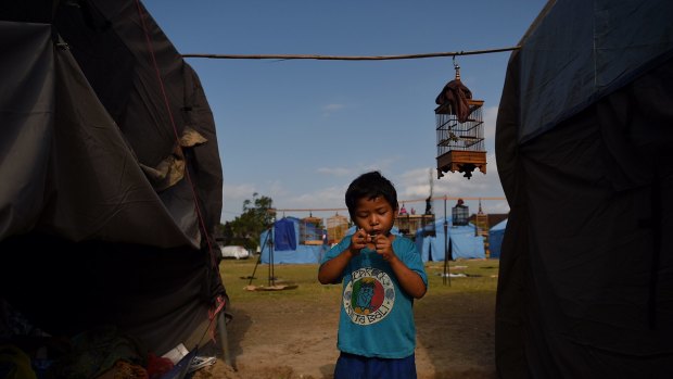 Komang Monda entertains himself amongst the tents at an evacuation camp in Klungkung city, home to thousands of peole who have been evacuated from red zones in preparation for the eruption of Mount Agung, Bali, Indonesia. 
