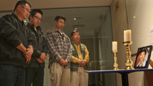 Simple shrine ... construction workers pay their respects to Myung Yeol Hwang.