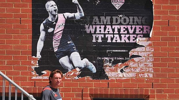 Essendon coach James Hird at the club's Windy Hill headquarters, with the club's 2013 promotional slogan above him.