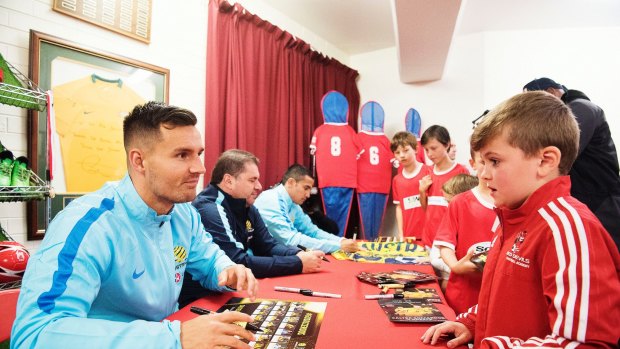 "After the win over Honduras he spoke to us all and told us how proud he was": Bailey Wright signs autographs, with Ange Postecoglou and Tim Cahill in the background.