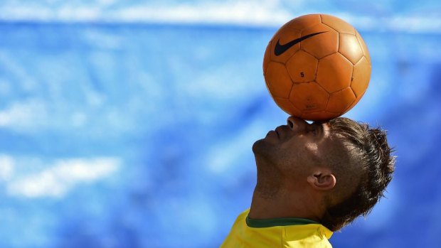 Juggling act ... A "lookalike" of the Brazilian footballer Neymar plays with a ball in front of the Vila Belmiro Stadium in Santos.