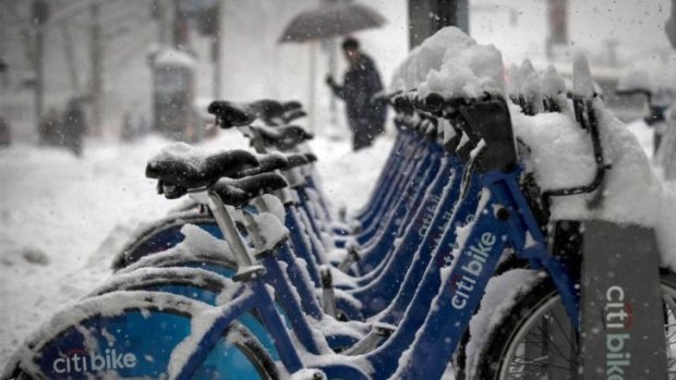 Citibikes are parked in a base station during a morning snow storm in New York's financial district.