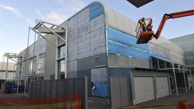 Asbestos cladding being removed from the exterior of the swimming pool building at the Australian Institute of Sport.