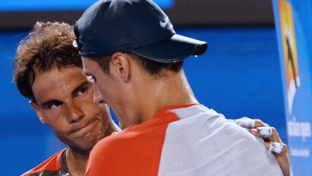 Australia's Bernard Tomic is comforted by Rafael Nadal after retiring in their first round match.