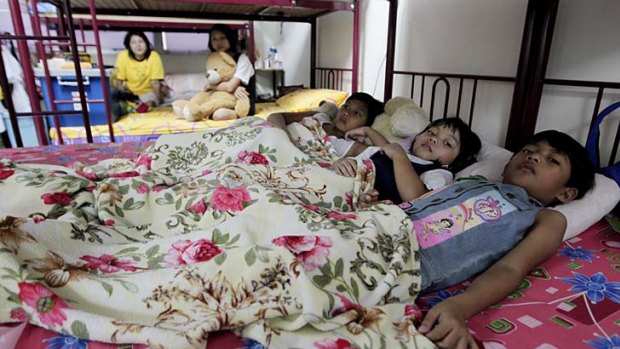 Myanmar refugees share a bed in their room in a suburb of Kuala Lumpur, Malaysia.
