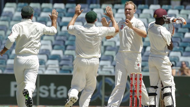 Teammates race in to congratulate Doug Bollinger, second from  right, after he claimed the wicket of Kemar Roach to win the third Test yesterday.