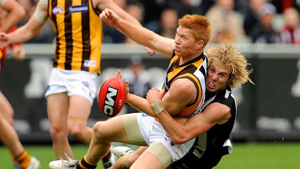 Wrapped up: Collingwood's Dale Thomas tackles Hawk Kyle Cheney at the MCG yesterday.