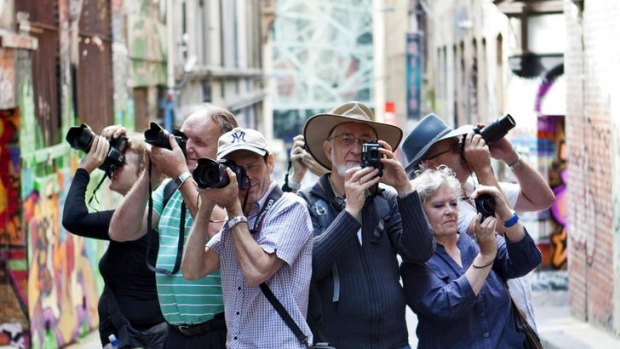 CAPTION: Participants hold their cameras in a laneway off Flinders Street and Flinders Lane on one of the Melbourne Photography Tours, February, 2012.. PICTURE CREDIT: Vincent Long 
 IMPORTANT USAGE information: This is not a Fairfax Image.  
 DO NOT ARCHIVE, for use only with story by Katie Cincotta, Thursday, March 1, 2012.