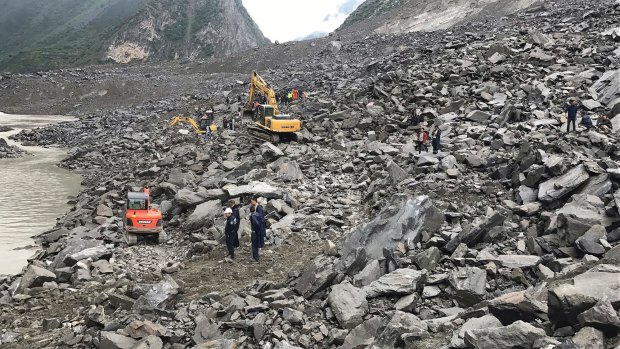 Emergency personnel at the site of a massive landslide in Xinmo village in China.