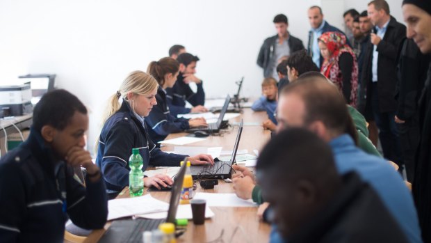Refugees and migrants are registered in a police facility in Moers, western Germany.