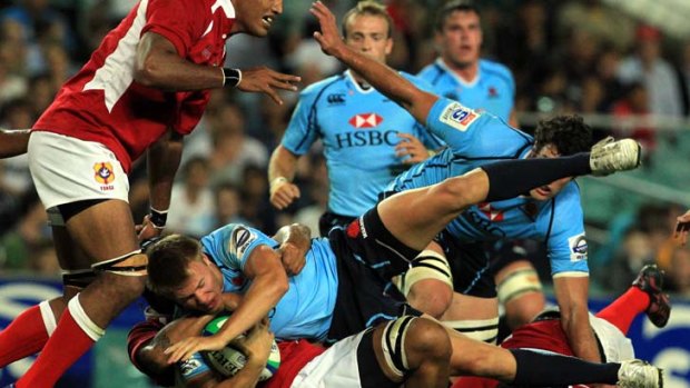 Diving in &#8230; youngster Tom Kingston is tackled in the Waratahs' trial match against Tonga at the SFS on Friday night.