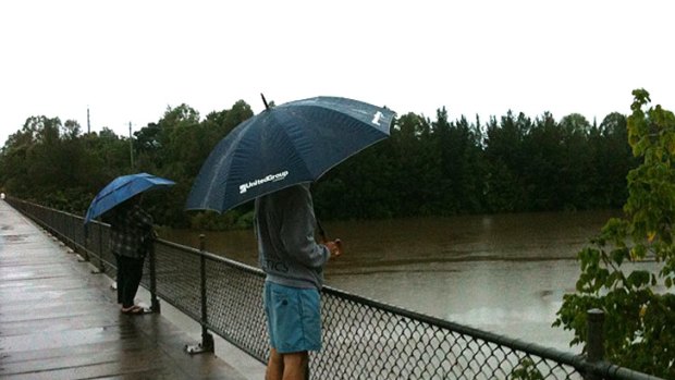 Onlookers watch the swollen Hawkesbury River at the North Richmond bridge, which is expected to be closed later today.